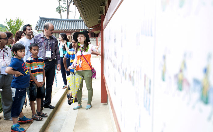 Participants listen as the tour guide explains the historical records that outline the 60th birthday celebration for King Jeongjo’s mother, at the Hwaseong Fortress in Suwon, Gyeonggi-do. 