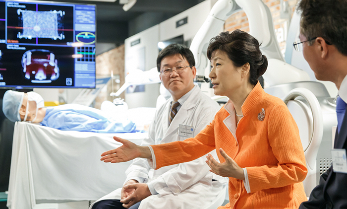 President Park Geun-hye shares her opinion with medical staff after learning about equipment that can detect and automatically cure cancer, at the Ulsan Center for a Creative Economy and Innovation on July 15.