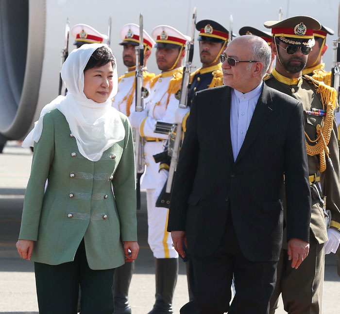 President Park Geun-hye (L), wearing a white scarf, inspects the military honor guard after arriving at Tehran Mehrabad International Airport on May 1.