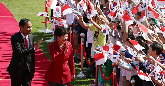 President Park Geun-hye and Indonesian President Joko Widodo wave at the children welcoming the Indonesian head of state to Seoul.