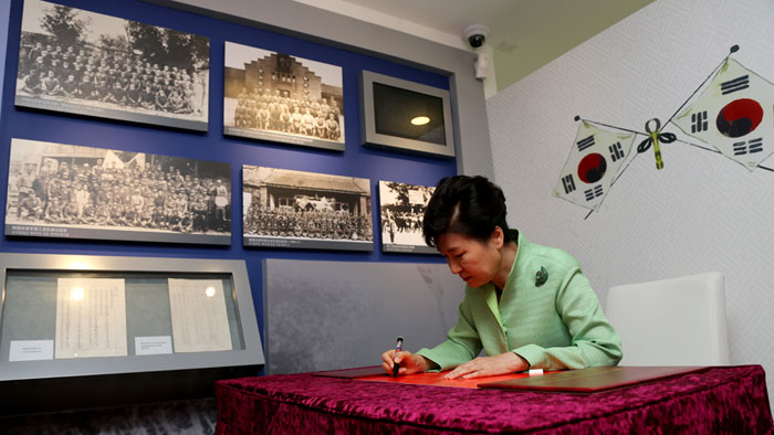 President Park Geun-hye signs the guestbook during her visit to the building of the Provisional Government of the Republic of Korea in Shanghai on Sept. 4.