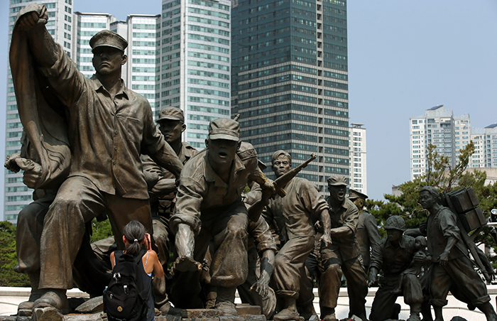  A non-Korean visitor takes a photo of a Korean War sculpture at the War Memorial of Korea on June 23. 