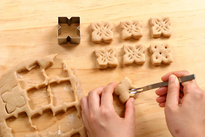 Roll the dough flat and use a cutter to make i>yakgwa</i>-shaped cookies. Poke 5 or 6 holes in them with a chopstick.