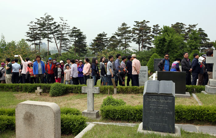Visitors look around the Yanghwajin Foreign Missionary Cemetery.