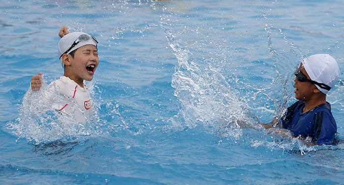 Children splash around at an outdoor swimming pool in Yeouido on August 3.