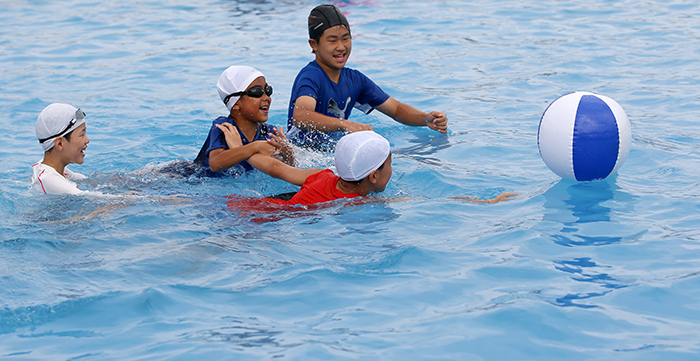 Children race for the ball at an outdoor pool on Aug. 3. Lifeguards are on duty at the outdoor swimming pools along the Hangang River riverside parks. All swimmers are required to take a 15-minute break every hour for safety reasons.