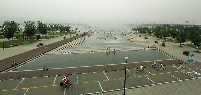 Park-goers enjoy the bike path and the giant fountain at the riverside Mulbit Square in Yeouido, Seoul, amid foggy, humid weather on August 5. (photo: Jeon Han)