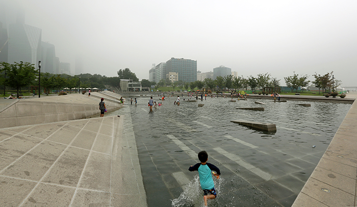 Children play in the water at the riverside Mulbit Square in Yeouido during the hot, humid weather on August 5. (photo: Jeon Han)
