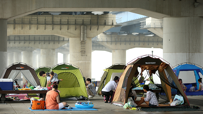 Families set up their tents under the Mapo Bridge along the riverside in Yeouido to fight off the sweltering heat during the dog days of summer on August 5. The riverside is the best refuge in Seoul during the tropical nights. (photo: Jeon Han)