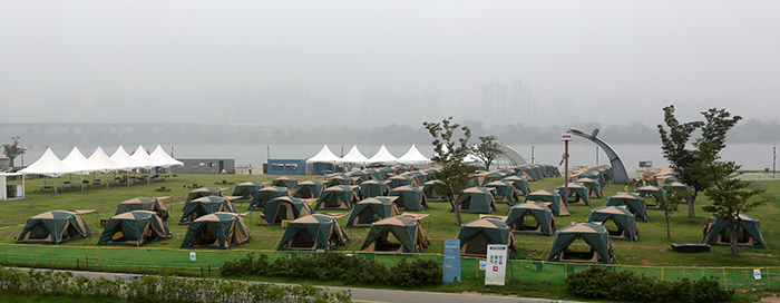 Vacationers can rent a tent for a night along the riverside in Yeouido. Without going far away, people can still enjoy their summer vacation in the city with friends and family. (photo: Jeon Han) 