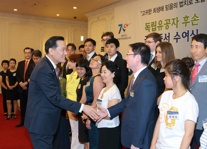 Minister of Justice Kim Hyun-woong shakes hands with descendants of independence activists during the ceremony.
