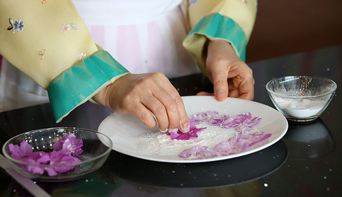 Trim the flower petals and dry them. Cover the petals with mung bean starch.