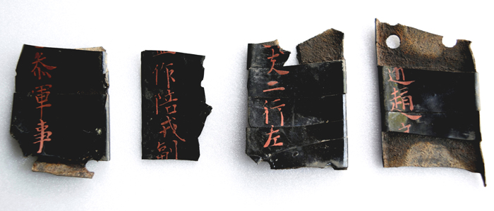 Pieces of lacquered armor are found in a Baekje water reservoir in Chungcheongnam-do. The characters in red clearly describe the wearer's title and post. (photo: the CHA) 