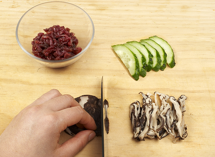 Cucumbers, beef and shitake mushrooms are needed to prepare <i>bibim guksu</i>. All the ingredients need to be cut into small pieces and marinated.