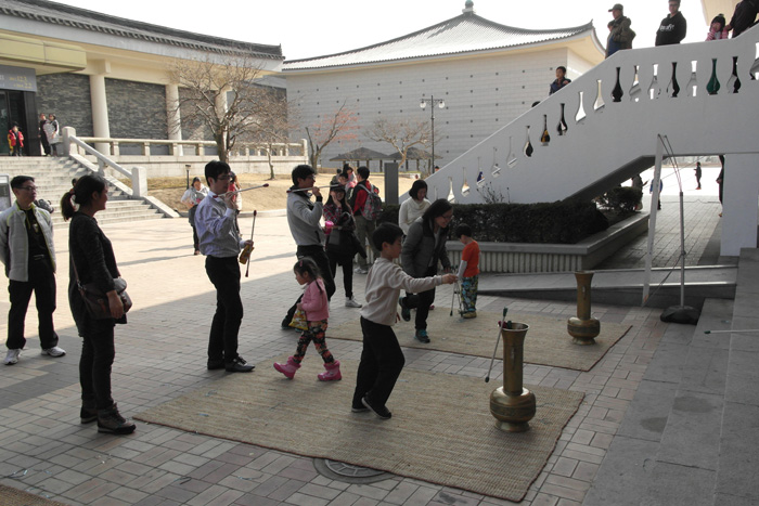 Visitors can watch a <i>samulnori</i> performance (top), knead rice cake dough with a large wooden mallet (middle) or throw arrows into a bottle at national museums across the country during the Lunar New Year holiday from February 18 to 22. 