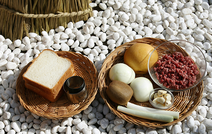 The ingredients of modern bulgogi include sirloin beef strips, onions, pears, garlic, green onions, soy sauce and a bit of kiwi for the marinade and bread.