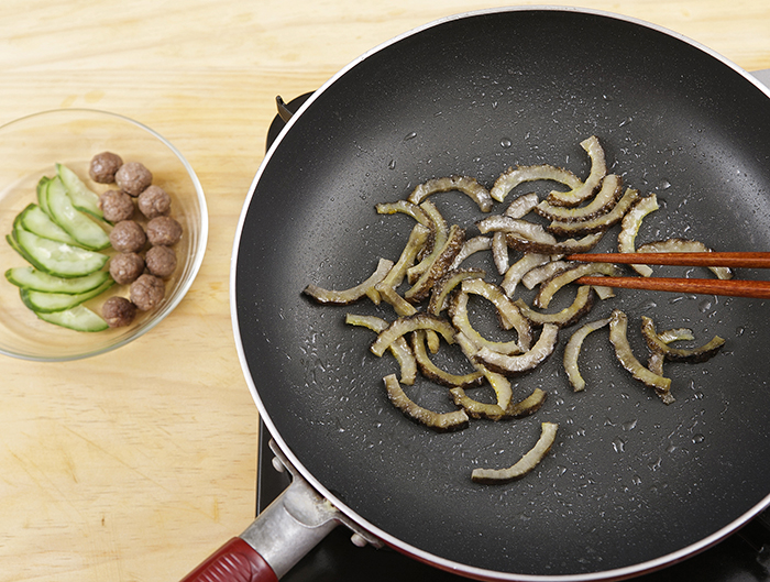 Fry the sea cucumber over medium for 1 minute. Cook the meat balls over high for 1 minute.