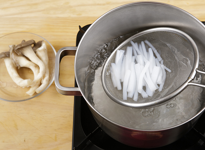 Put the salt and mung bean jelly in a pot with boiling water and cook it for 30 seconds. Cook the mushrooms in the pot for 1 minute and shred the cooked mushrooms. If the mung bean jelly is hardened, blanch the jelly in the boiling water for just a few seconds.
