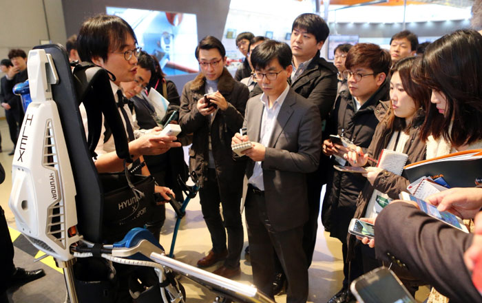 The government will expand its investment in the health & wellness sector by including ICT as part of its national informatization plan. Visitors to the 2015 Creative Economy Expo listen to an explanation about a robot designed to help disabled people who can't use their legs.