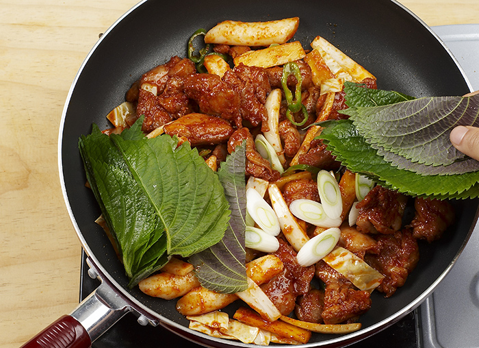 Heat a pan with cooking oil. Add the chicken and sweet potato to the pan and stir-fry it all for 5 minutes over a medium heat. Add all the other ingredients -- rice cake, cabbage, green peppers, onions and remaining seasoning – to the pan and stir-fry it all for 4 minutes.