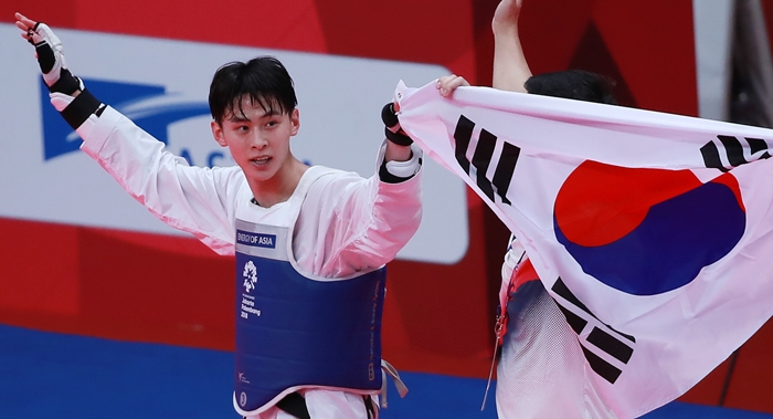 The gold medalist in the men's 58k g taekwondo division, Kim Taehun, bows to the spectators with the Taegeukgi Korean national flag in his hands, at the Jakarta Convention Center (JCC) in the Indonesian capital on Aug. 20. (Yonhap News)
