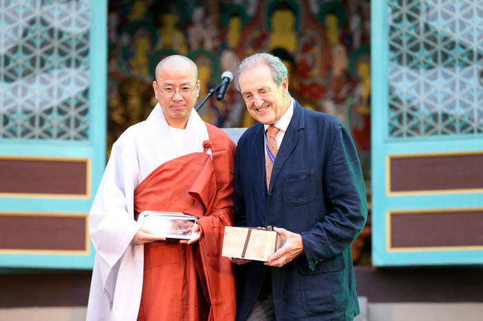 The Ven. Yeongwang (left) and FISU President Claude-Louis Gallien exchange gifts before the dinner.