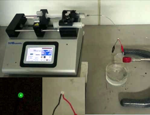 An LED is lit as a drop of water falls on the glass plate transducer.