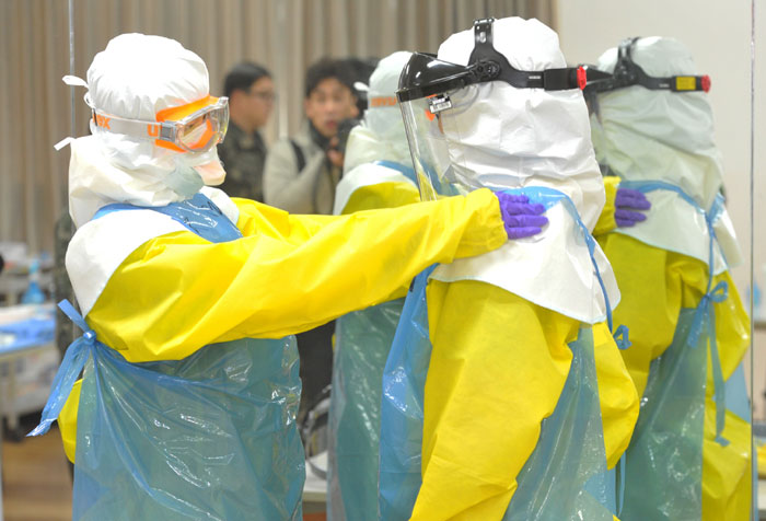 Staff at the Korea Armed Forces Nursing Academy try on the protection suits that will be worn by medical workers dispatched to Sierra Leone.
