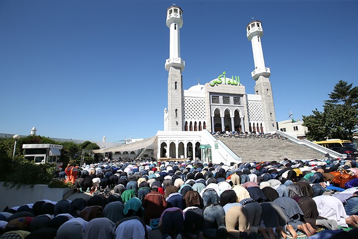 The devout join hands in prayer at the Seoul Central Masjid, the first mosque in Korea, on Sept. 1 to celebrate <i>Eid al-Adha.</i>