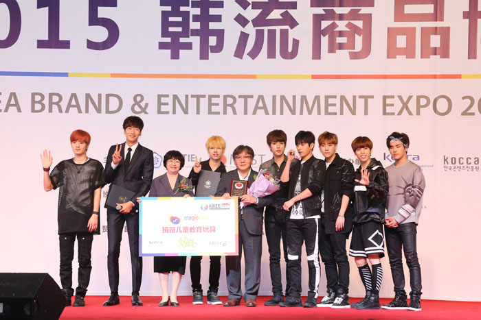 TV star Lee Kwang-soo (second from left), members of the pop group Infinite and other officials appear on stage for a photo.