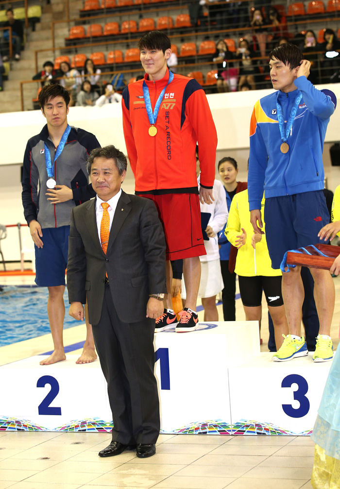 Park Tae-hwan (middle) stands on the podium after winning a gold medal in the 200-meter freestyle event. 