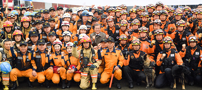 President Moon Jae-in poses for a photo with firefighters on the 55th anniversary of Firefighters Day at the Fire Service Academy in Cheonan, Chuncheongnam-do Province, on Nov. 3.