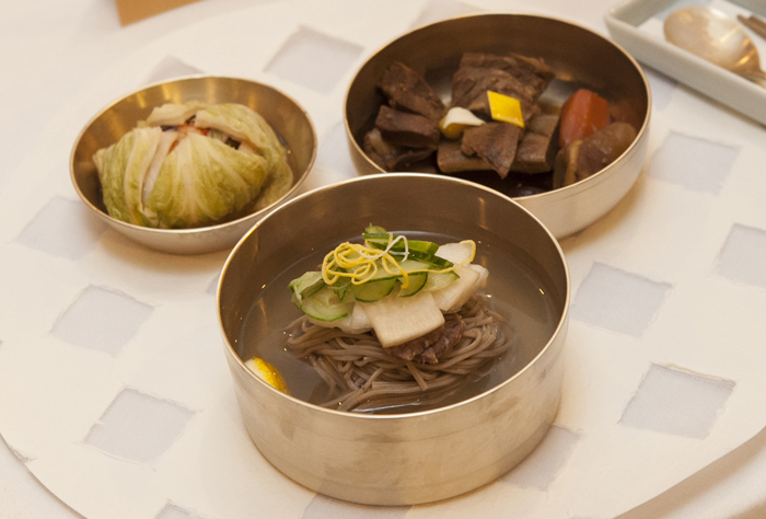 (From top, clockwise) Braised short beef ribs, kimchi, noodles in radish and pear water kimchi broth.