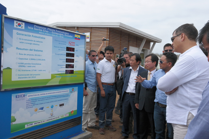 Ecuadorian President Rafael Correa (right) and officials from both Korea and Ecuador inspect a monitor explaining the solar power plant's operations. 