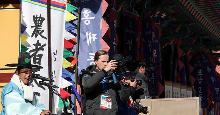 Eurosport journalist Barcosz Zanus from Poland films the traditional group bow in Gangneung on Feb. 17.