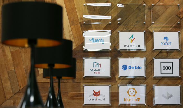 Logos for startup companies and partners at Camus Seoul are displayed on the wall.