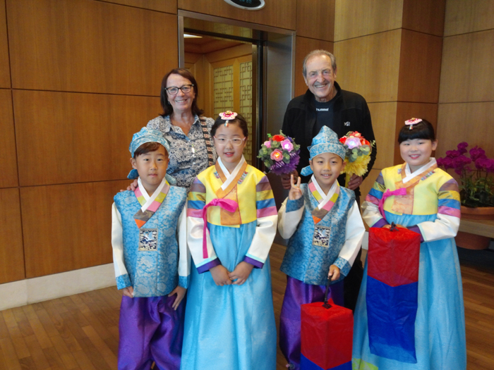 FISU President Claude-Louis Gallien (rear, right) and his wife hold gifts they received from the children. .