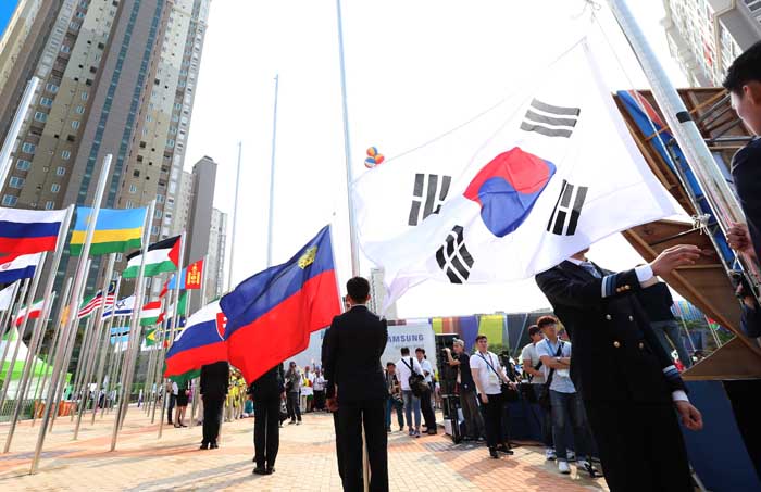 Flags of the participating nations are raised.