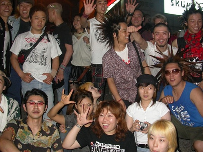 Korean and Japanese punks and skinheads pose for a group photo outside Skunk Hell.