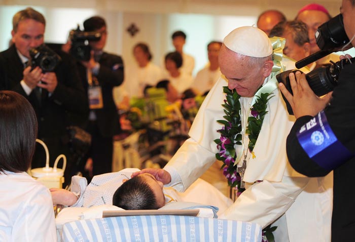  Pope Francis blesses a sick child at Kkotdongnae, a welfare facility in Eumseong County, Chungcheongbuk-do, August 16. 