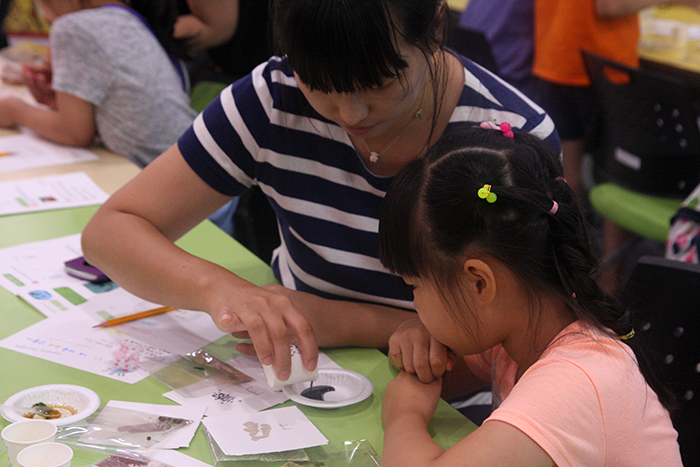 Parents and children learn about food from Korea, Indonesia and Uzbekistan as they mix their own spices.