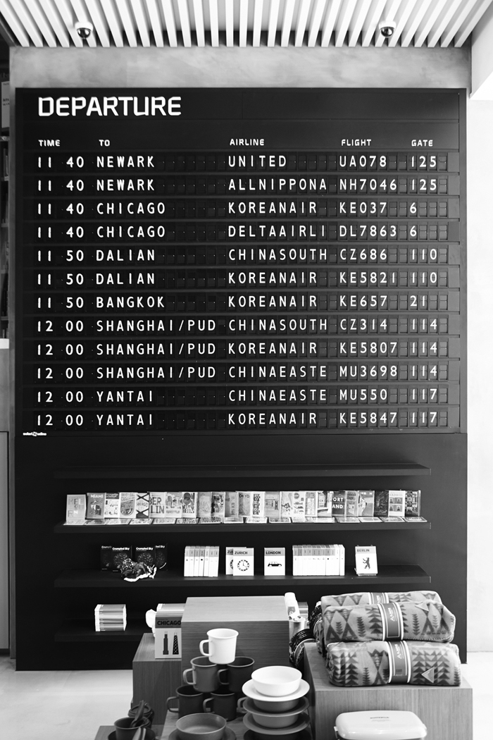 (Top) A colorful travel book bookshelf with a map printed on the shelves. (Bottom) An antique flight information board. (photos courtesy of Hyundai Card)