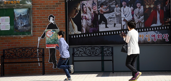 A mother and son head toward the entrance of the Masil Cinema.