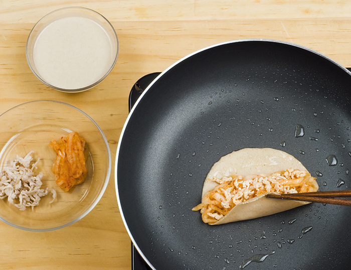 Cook the pancakes in a preheated frying pan over a low heat. Be sure to make very thin pancakes so as to have a better texture. Place the filling on the pancake, roll it up and cook it in the pan.