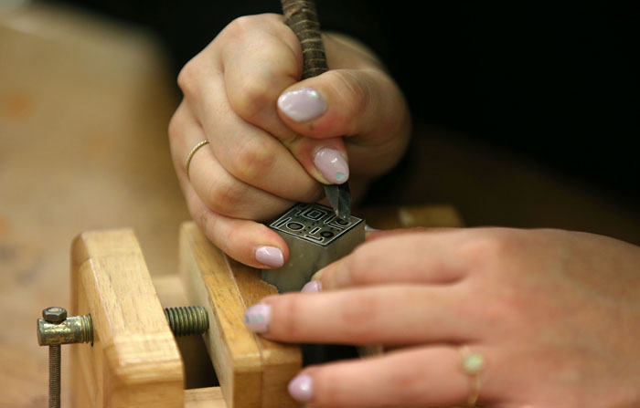  A participant in the seal-making program carefully engraves her name on the stamp. 