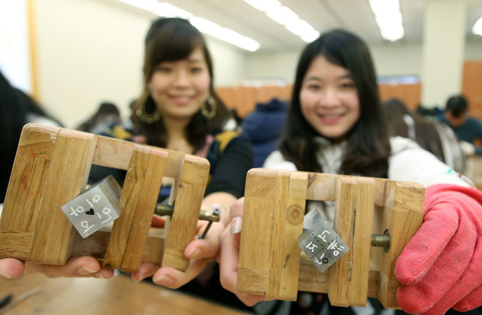 International students attending Yonsei University's Korean Language Institute smile as they show off the seals displaying their names. 