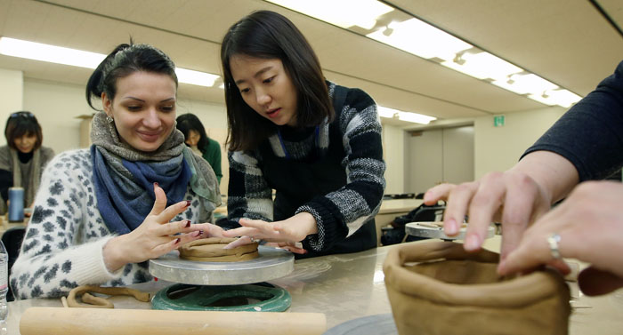  Elena Popova, a Russian student attending the Korean language program at the Korea University of International Studies (left), makes a ceramic vase at the National Museum of Korea on January 28. 