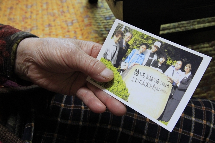 Kim Sung-ju, who was forced to work for the Japanese company Mitsubishi during Japan’s colonial rule of the Korean Peninsula (1910-45), holds a photo she took with her Japanese supporters in front of the memorial stone for the 56 people who died in the 1944 Tonankai earthquake, including six young Korean forced laborers. (Kim Young Shin)