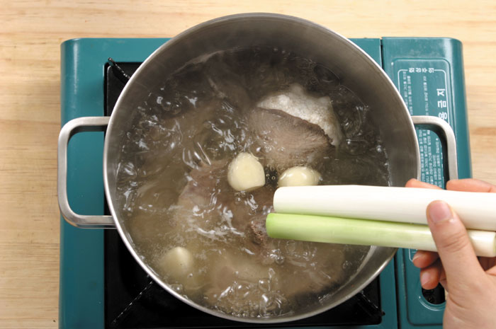 Put the knee bone and all the beef cuts into a pot and boil it for 1 hour over high heat. Then lower the heat to medium and let it simmer for 5 hours while skimming off the foam and fat that forms on the surface. Add the tongue, brisket and shank to the pot and boil for 1 hour. Add the seasoning and boil for another hour. Then boil it for a final 30 minutes after reducing the heat to low.