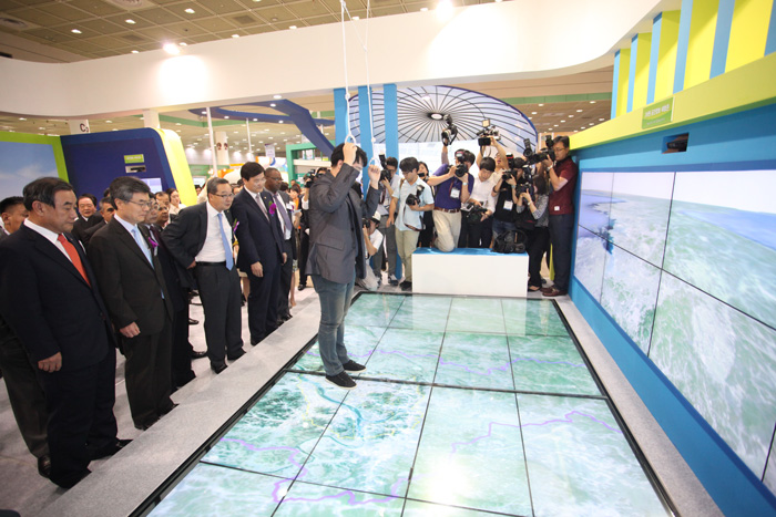  (Top) Participants in the 2014 Smart Geospatial Expo watch a spatial information clearinghouse simulation on the opening day. (Bottom) The Korea Land and Housing Corp. showcases its virtual reality system. (photos courtesy of the Ministry of Land, Infrastructure and Transport) 